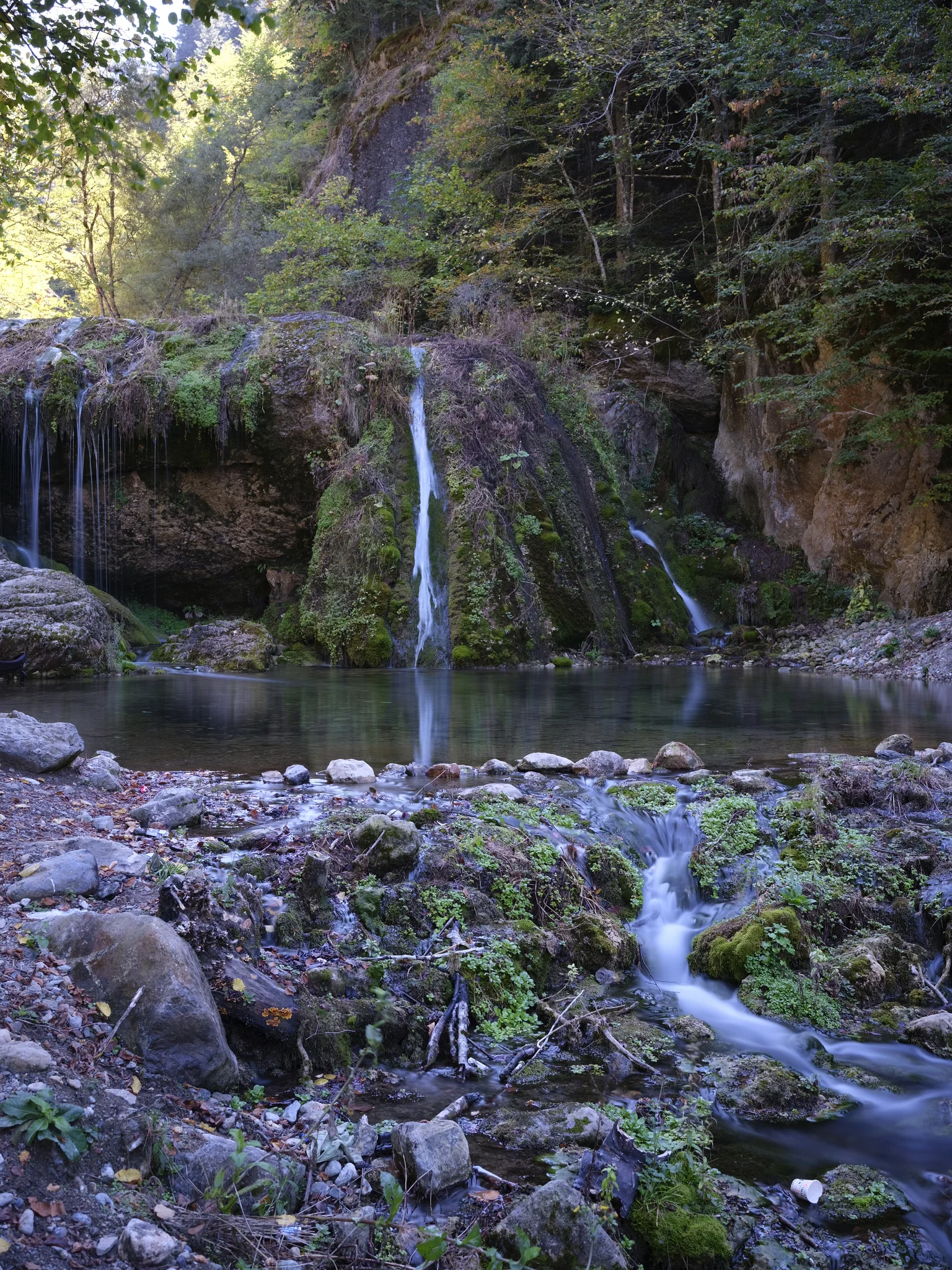 Wasserfall und Bach, die über moosbewachsene Felsen stürzen; 61 Sekunden Belichtungszeit.
