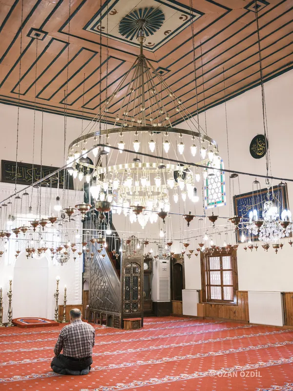 Avizelerin altında namaz kılan biri ve minber.